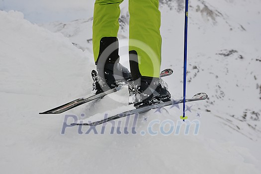 skier skiing downhill on fresh powder snow with sun and mountains in background skier skiing downhill on fresh powder snow with sun and mountains in background