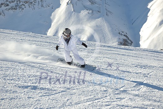 skier skiing downhill on fresh powder snow with sun and mountains in background skier skiing downhill on fresh powder snow with sun and mountains in background
