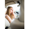 Cute female teen driver enjoying her freshly acquired driving license at the wheel of her first car