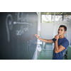 Students in a classroom - handsome student solving a math problem on a blackboard during math class