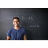 Students in a classroom - handsome student solving a math problem on a blackboard during math class
