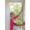 Pretty, young woman washing windows of her household. Cleaning with a detergent (shallow DOF)