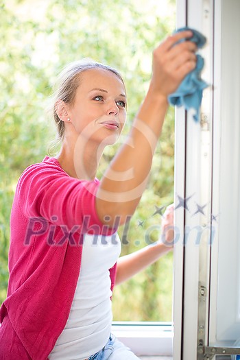 Pretty, young woman washing windows of her household. Cleaning with a detergent (shallow DOF) Pretty, young woman washing windows of her household. Cleaning with a detergent (shallow DOF)