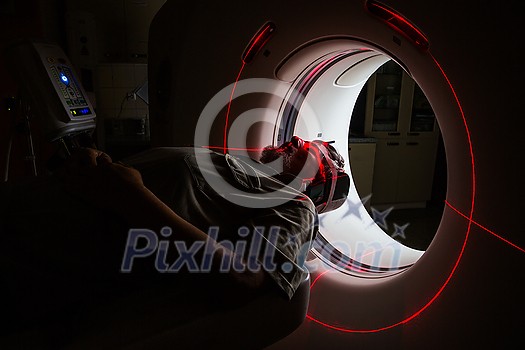 Senior man going through a Computerized Axial Tomography (CAT) Scan medical test/examination in a modern hospital (color toned image; shallow DOF) Senior man going through a Computerized Axial Tomography (CAT) Scan medical test/examination in a modern hospital (color toned image; shallow DOF)