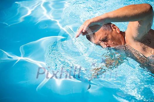 Senior man in his home swimming pool, enjoying the deserved retirement Senior man in his home swimming pool, enjoying the deserved retirement