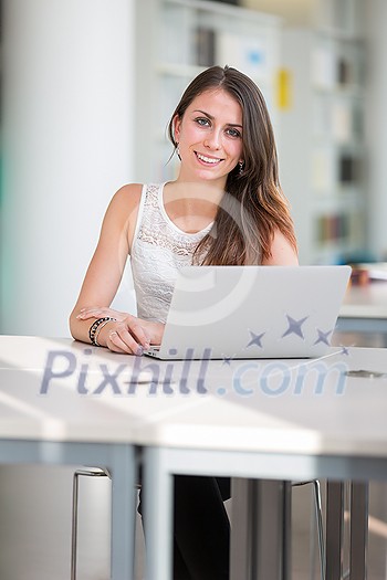 Pretty young college student in a library (shallow DOF; color toned image) Pretty young college student in a library (shallow DOF; color toned image)