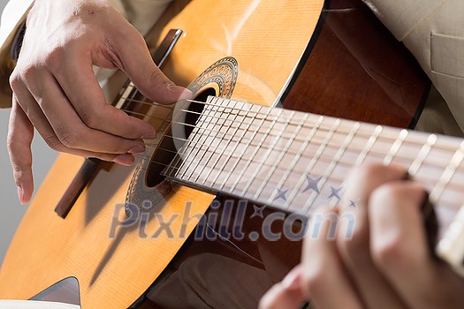 Close up of male hands playing acoustic guitar Close up of male hands playing acoustic guitar