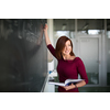 Pretty, young college student writing on the chalkboard, blackboard during a math class