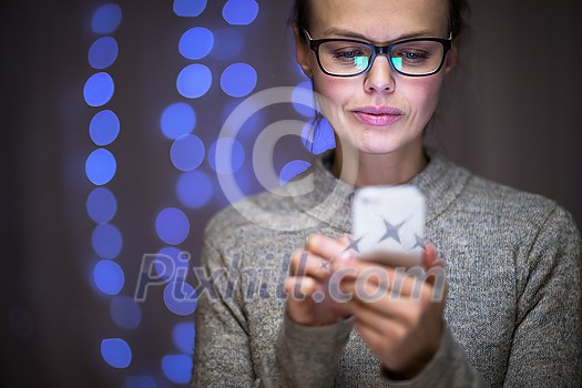 Young woman using her cell phone at home Young woman using her cell phone at home