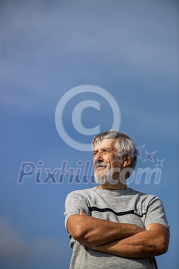 Happy senior man outdoors against the sky on a warm summer day Happy senior man outdoors against the sky on a warm summer day