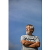 Happy senior man outdoors against the sky on a warm summer day