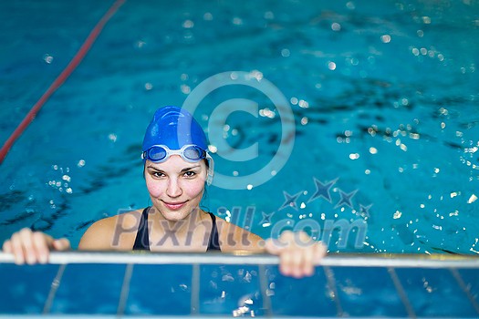 Female swimmer in an indoor swimming pool - looking at the camera, smiling wholeheartedly (shallow DOF; color toned image)(shallow DOF) Female swimmer in an indoor swimming pool - looking at the camera, smiling wholeheartedly (shallow DOF; color toned image)(shallow DOF)