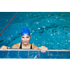 Female swimmer in an indoor swimming pool - looking at the camera, smiling wholeheartedly (shallow DOF; color toned image)(shallow DOF)