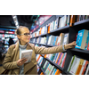 Pretty, young female choosing a good book to buy in a bookstore