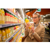 Pretty, young woman shopping for her favorite fruit juice/smoothie at a grocery store