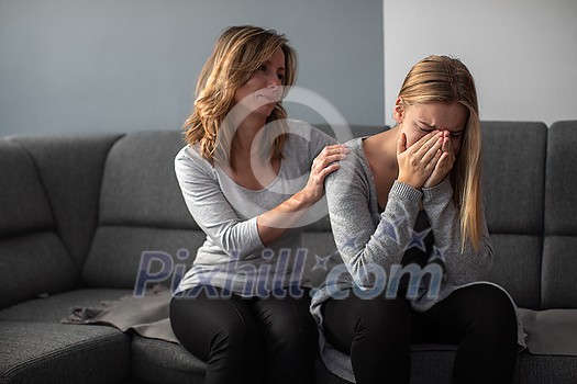 Depressed teen suffering from anxiety being taken care of by her caring mother Depressed teen suffering from anxiety being taken care of by her caring mother