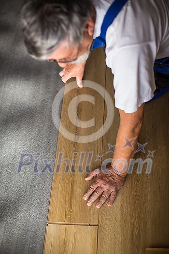 DIY, repair, building and home concept - close up of male hands lying parquet floor board/laminate flooring (shallow DOF; color toned image) DIY, repair, building and home concept - close up of male hands lying parquet floor board/laminate flooring (shallow DOF; color toned image)