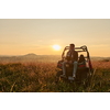portrait of young happy excited man enjoying beautiful sunny day while driving a off road buggy car on mountain nature