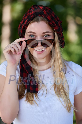 Outdoor portrait of beautiful, emotional, young woman in sunglasses. Soft background. Copy space Outdoor portrait of beautiful, emotional, young woman in sunglasses. Soft background. Copy space