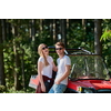 portrait of young happy excited couple enjoying beautiful sunny day while driving a off road buggy car on mountain nature