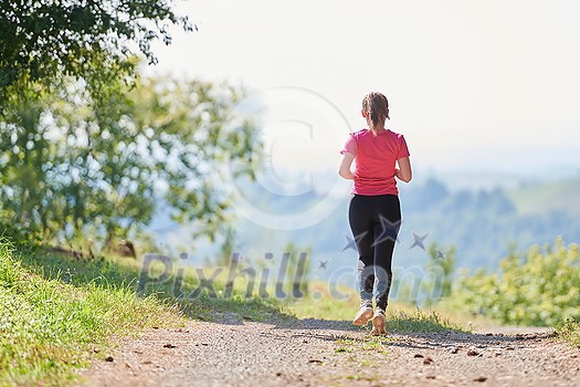 woman enjoying in a healthy lifestyle while jogging on a country road through the beautiful sunny forest, exercise and fitness concept woman enjoying in a healthy lifestyle while jogging on a country road through the beautiful sunny forest, exercise and fitness concept
