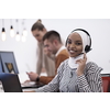 beautiful modern african Muslim businesswoman in office, wearing hijab speaking on headset at modern startup coworking space