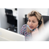 Female call center operator talking to a customer. Businesswoman in mask at the workplace in the  modern office. Social distance and safety outbreak new normal concept