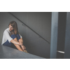 Depressed young woman sitting in a staircase, jobloss due to coronavirus pandemic, Covid-19 outbreak. Unemployment, economic crisis, financial distress concept