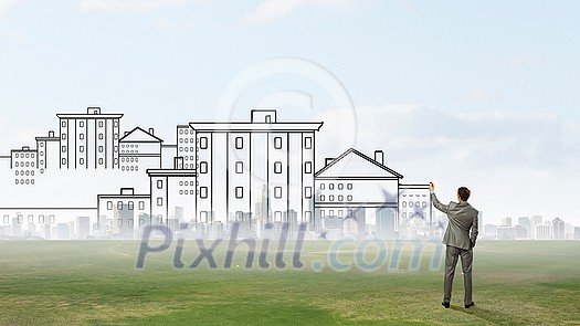 Back view of man engineer drawing plan sketches on wall Back view of man engineer drawing plan sketches on wall