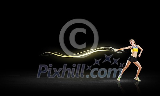 Young woman athlete running fast on dark background Young woman athlete running fast on dark background