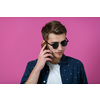 a portrait of a young man wearing a blue shirt and sunglasses using a smartphone with different facial expressions