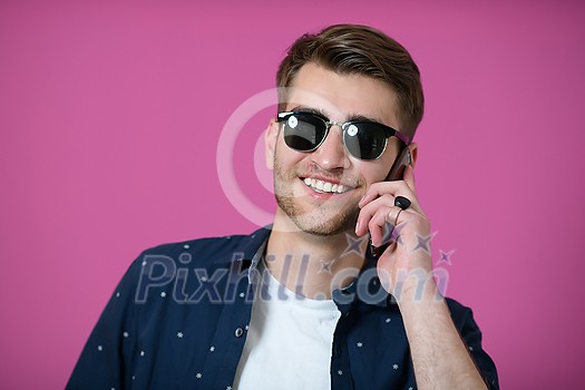 a portrait of a young man wearing a blue shirt and sunglasses using a smartphone with different facial expressions a portrait of a young man wearing a blue shirt and sunglasses using a smartphone with different facial expressions
