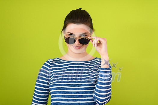 a beautiful woman in sunglasses posing in front of a green background
a beautiful woman in sunglasses posing in front of a green background