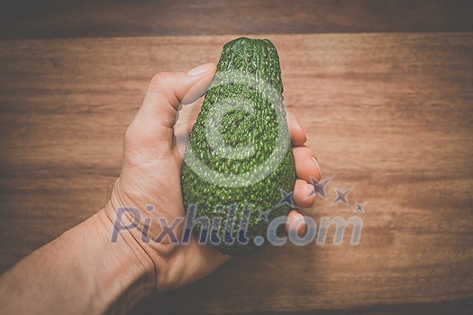 Close-up of a hand holding an avocado - locally sourced, organic food Close-up of a hand holding an avocado - locally sourced, organic food