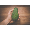 Close-up of a hand holding an avocado - locally sourced, organic food