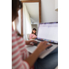 Successful young business woman sitting in a designer chair, working from home. Portrait of happy entrepreneur working on a laptop computer. Doing business remotely from the comfort of her home.