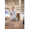Pretty, young woman choosing the right furniture for her apartment in a modern home furnishings store (color toned image; shallow DOF)