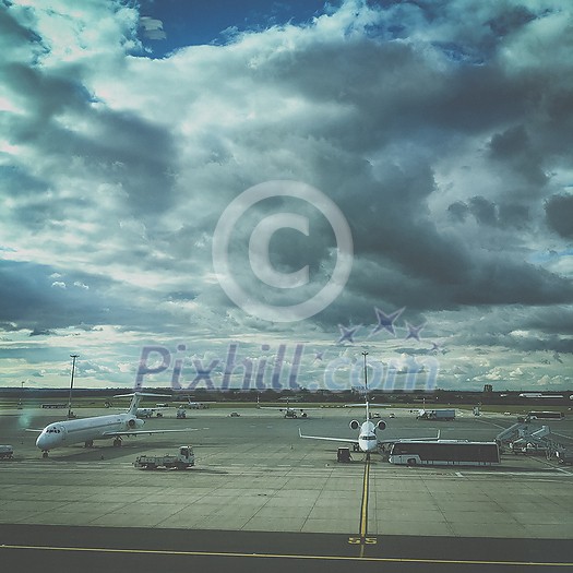Airport view with aircraft in the parking lot, airplane landing, plane flying in the sky. Air logistic, planes at airport. Travel and transportation concept. Empty place for text, copy space. Airport view with aircraft in the parking lot, airplane landing, plane flying in the sky. Air logistic, planes at airport. Travel and transportation concept. Empty place for text, copy space.