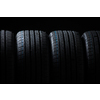Stack of brand new high performance car tires on clean high-key white studio background