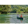 Couple adventurous explorer friends are canoeing in a wild river surrounded by the beautiful nature