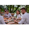 group of happy friends having picnic french dinner party outdoor during summer holiday vacation near the river at beautiful nature