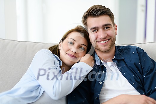 Relaxed young couple watching tv at home in bright living room
Relaxed young couple watching tv at home in bright living room