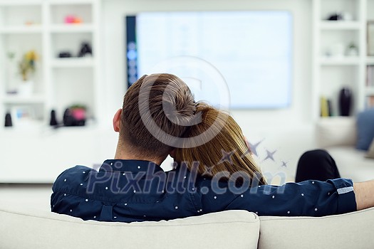 Relaxed young couple watching tv at home in bright living room
Relaxed young couple watching tv at home in bright living room