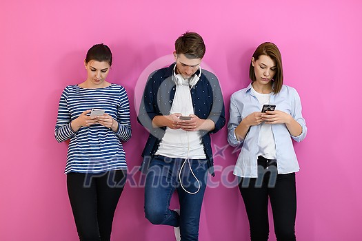 a group of friends have fun and dance while using a cell phone and headphones isolated on a pink background a group of friends have fun and dance while using a cell phone and headphones isolated on a pink background