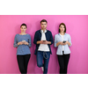 a group of friends have fun and dance while using a cell phone and headphones isolated on a pink background