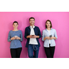 a group of friends have fun and dance while using a cell phone and headphones isolated on a pink background