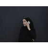 Young muslim businesswoman in traditional clothes or abaya talking on the smartphone. Arab woman  in front of black chalkboard and representing techology, islamic  fashion and Ramadan kareem concept