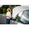 Pretty middle aged woman having car troubles - broken down car on the side of the road, calling the insurance company for assistance