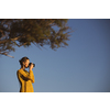Pretty, young woman with a mirrorless camera, taking photos by the sea