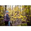 Pretty, young woman with her mountain bike going for a ride past the city limits, getting her dose of daily cardio